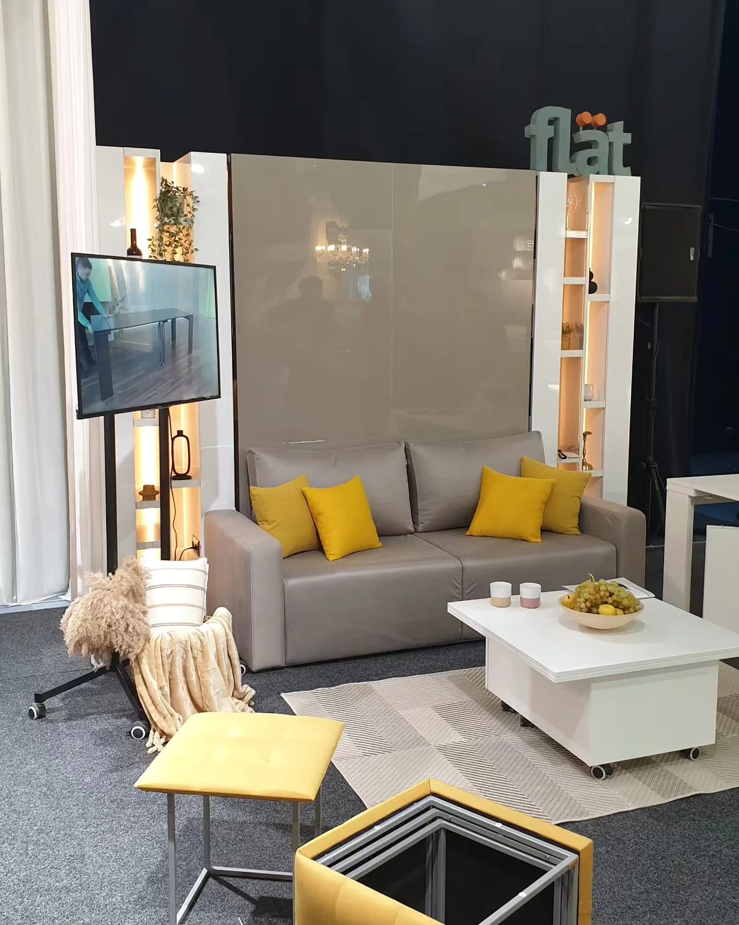 The flät stand at DAS Interior Salon 2023: a grey sofa and the bed closed in the wall